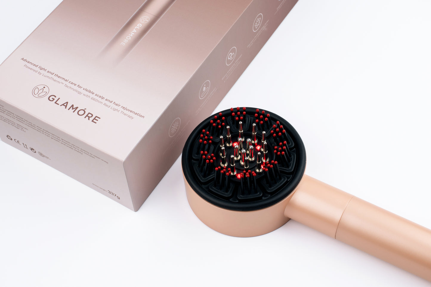 Close-up of the LUXÉRA scalp massager's red light (LumiTherm™ Technology) nodes, resting next to its premium box.
