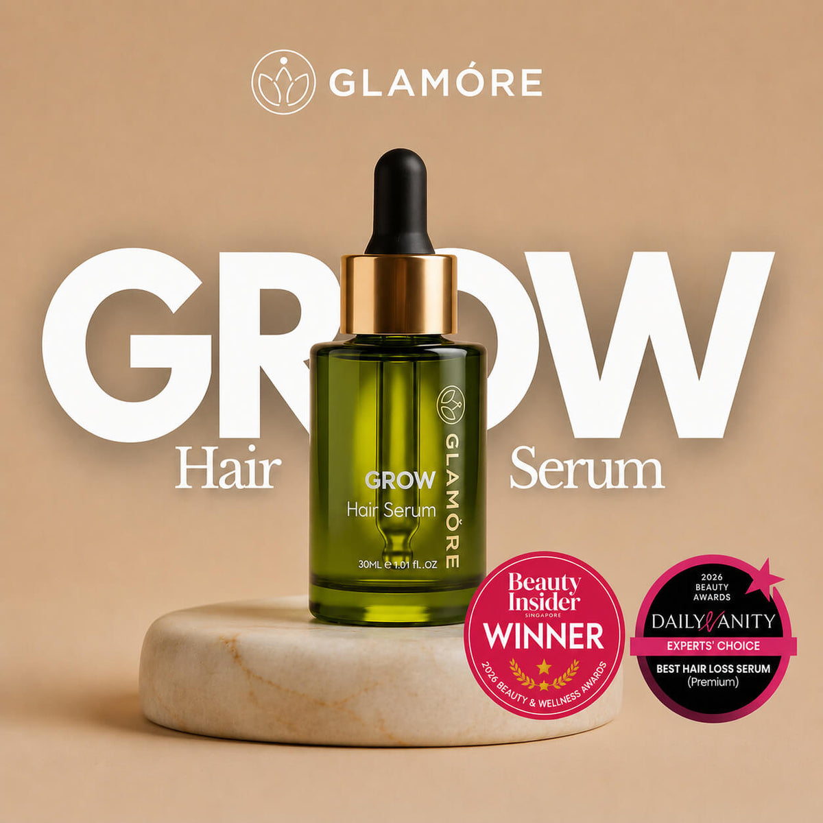 Glamoré Grow Hair Serum in a green glass dropper bottle with a gold collar, displayed on a marble coaster against a beige background with promotional text and award badges.
